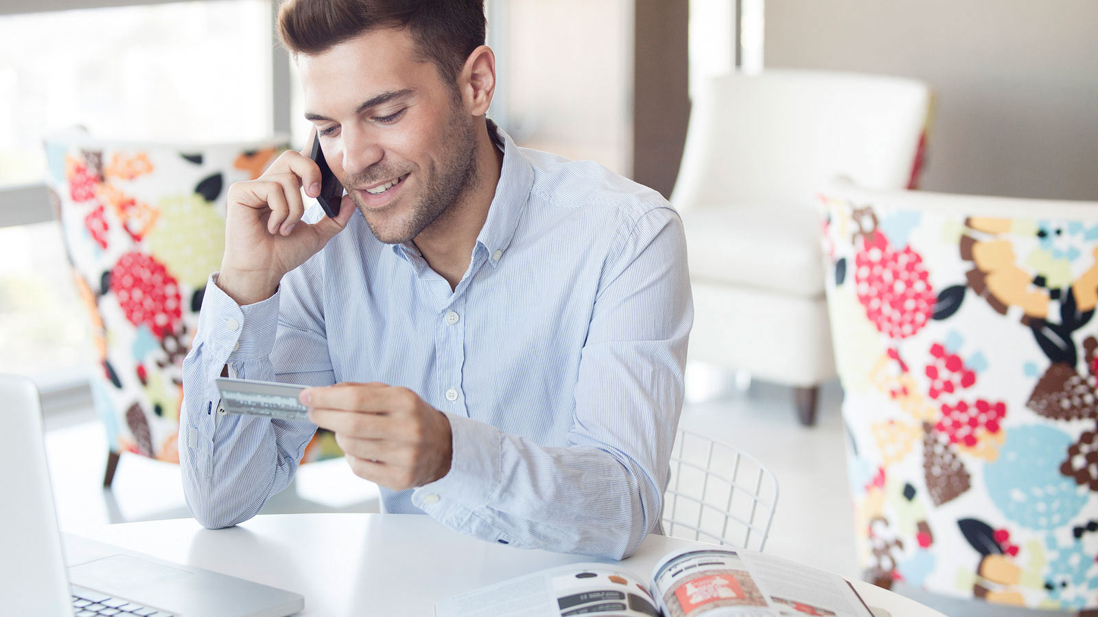 Mies hoitaa pankkiasioita puhelimella.