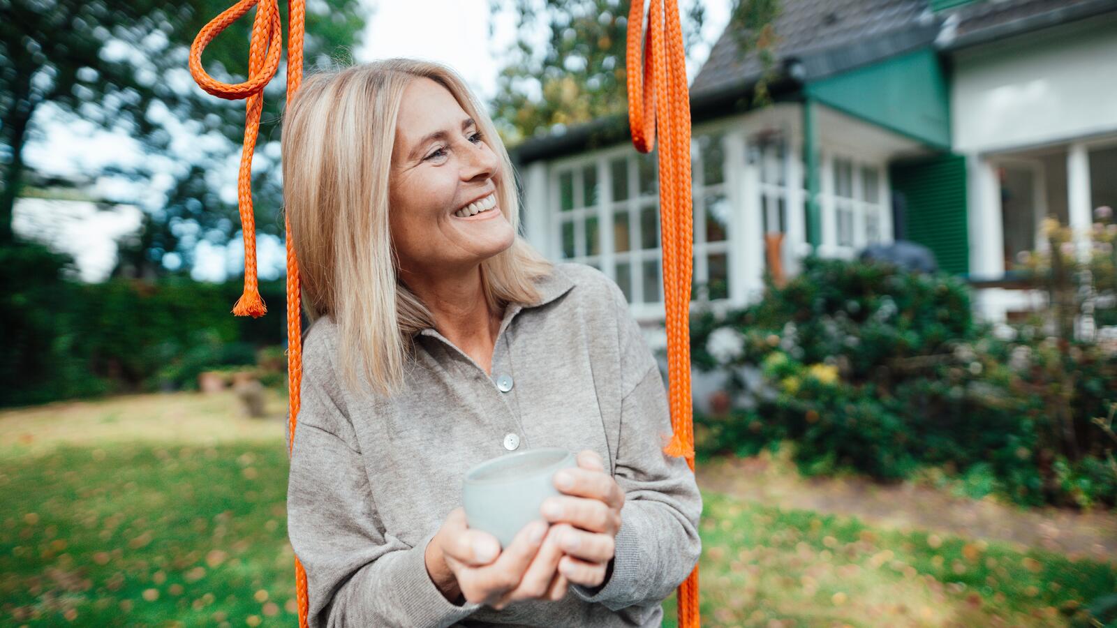 Kuvassa nainen istuu keinussa hymyillen, jätettyään vakuutustarjouksen.