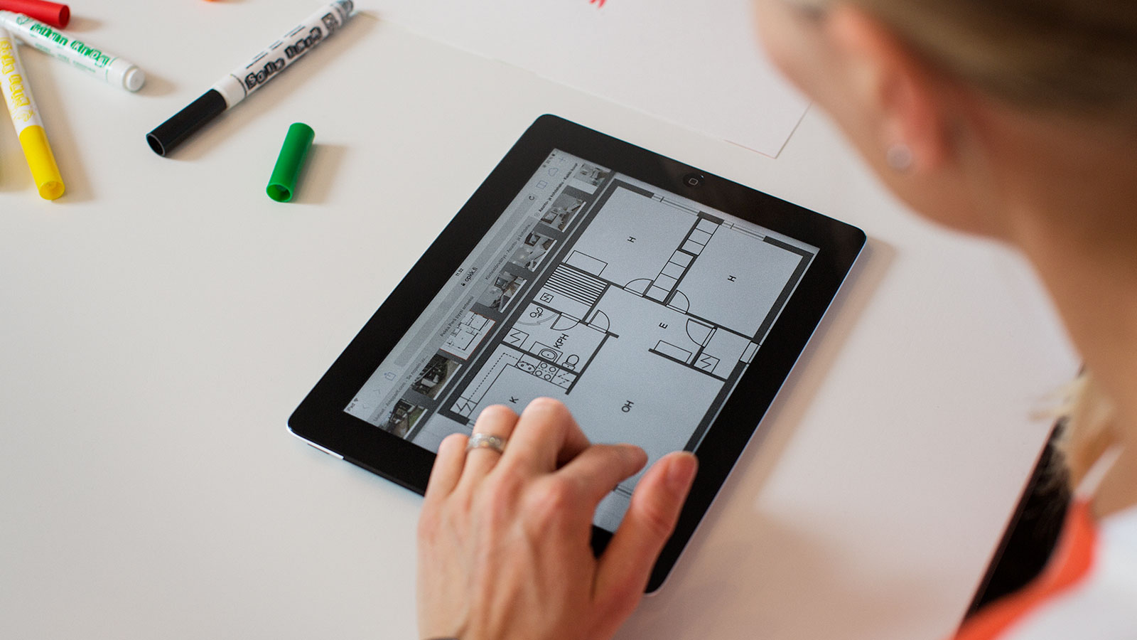 Nainen katsoo iPadilta talon pohjapiirrustusta.