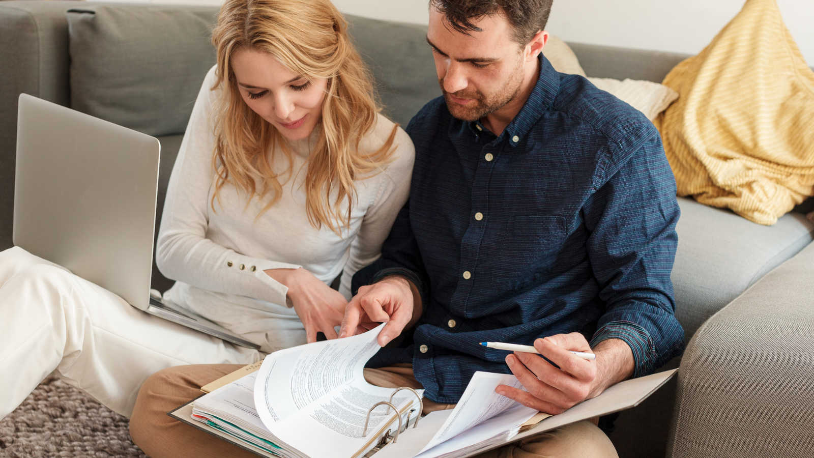 Pariskunta tietokoneella maksamassa laskuja.