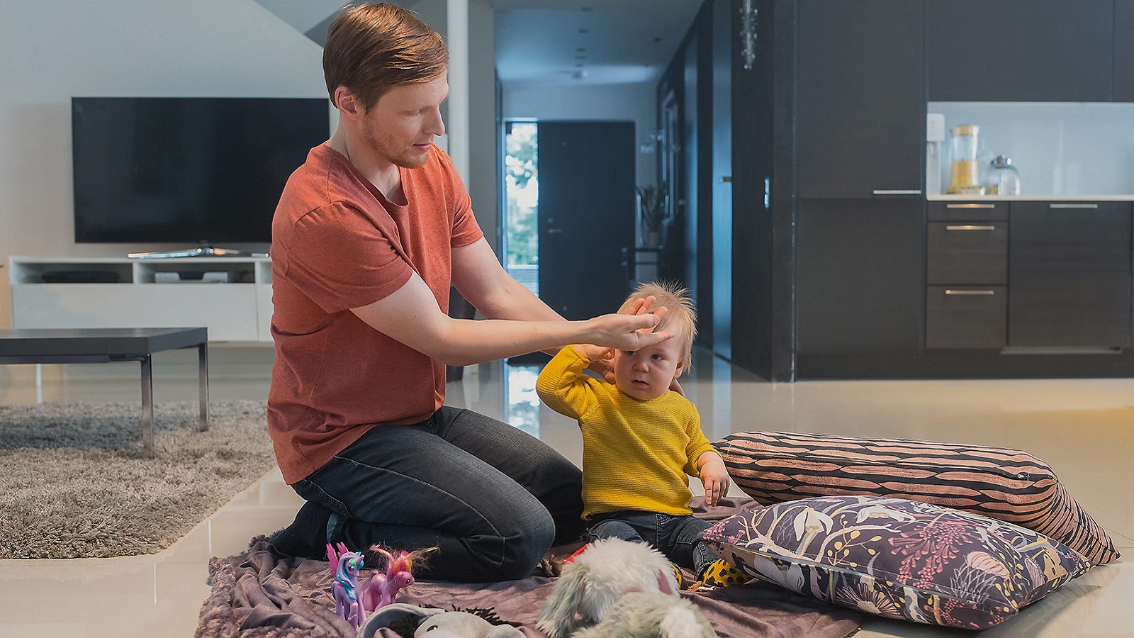 Isä mittaa lapselta kuumeen