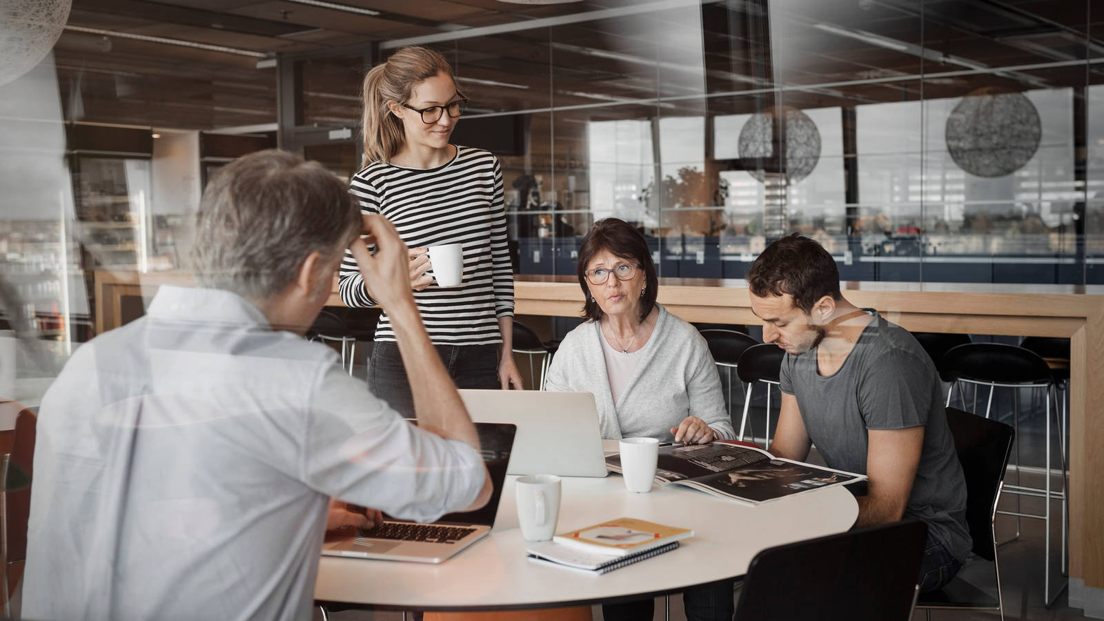 Hyvinvoiva työyhteisö yhdessä kahvihuoneessa huolettomina, sillä heidät on vakuutettu myös Työntekijäin Ryhmähenkivakuutuksella.