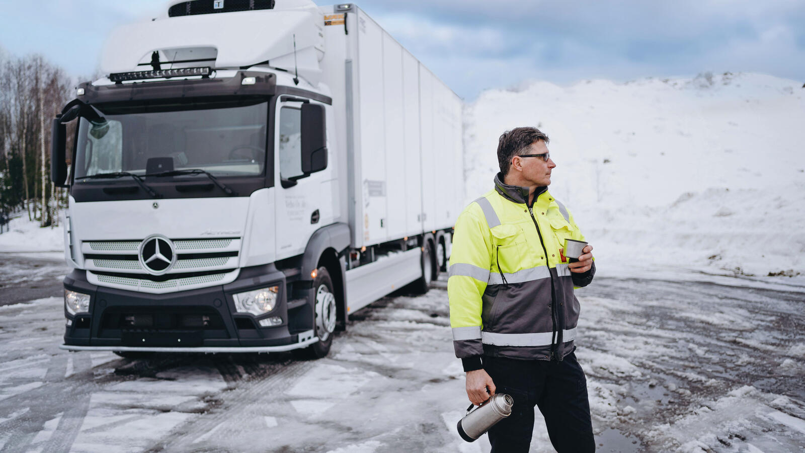 Kuvassa on rekka-auto ja kuljettaja, joka on juuri pyytänyt tarjouksen yrityksen vakuutuksista.