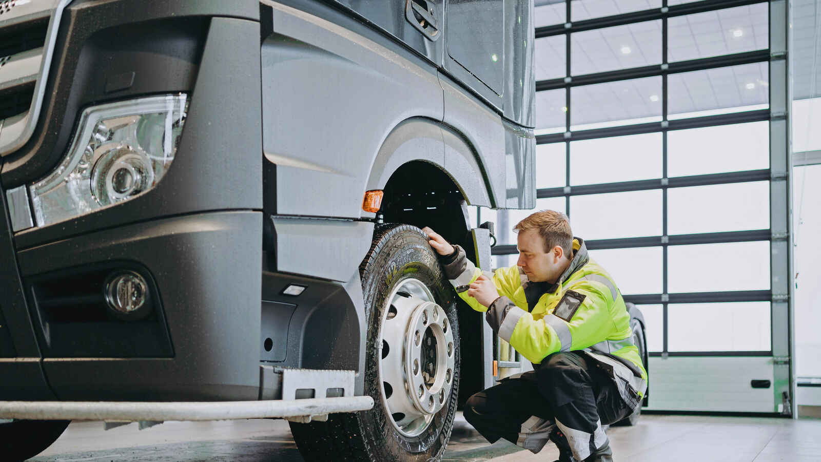 Kuvassa mies tutkii rekan rengasta.