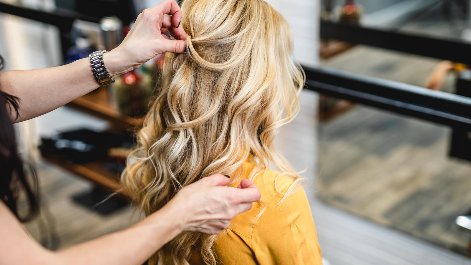 Kauneudenhoitoalan vakuutukset turvaavat kuvassa kampaajalla olevan asiakkaan