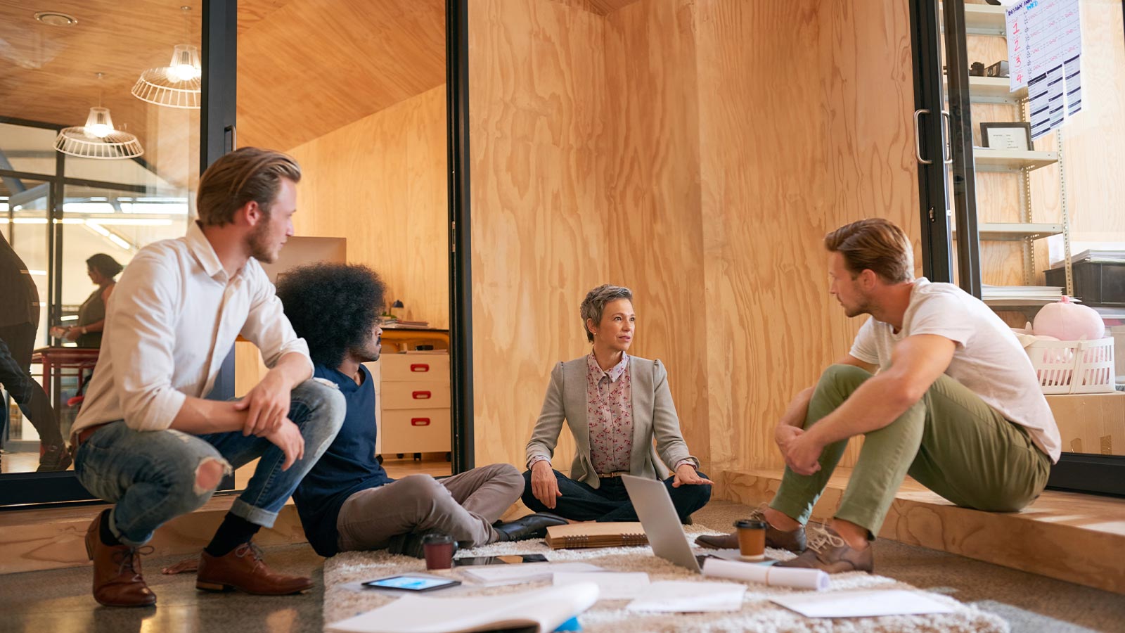 Neljä konsulttia keskustelemassa yritysvakuutuksista yrityksen toimistossa.