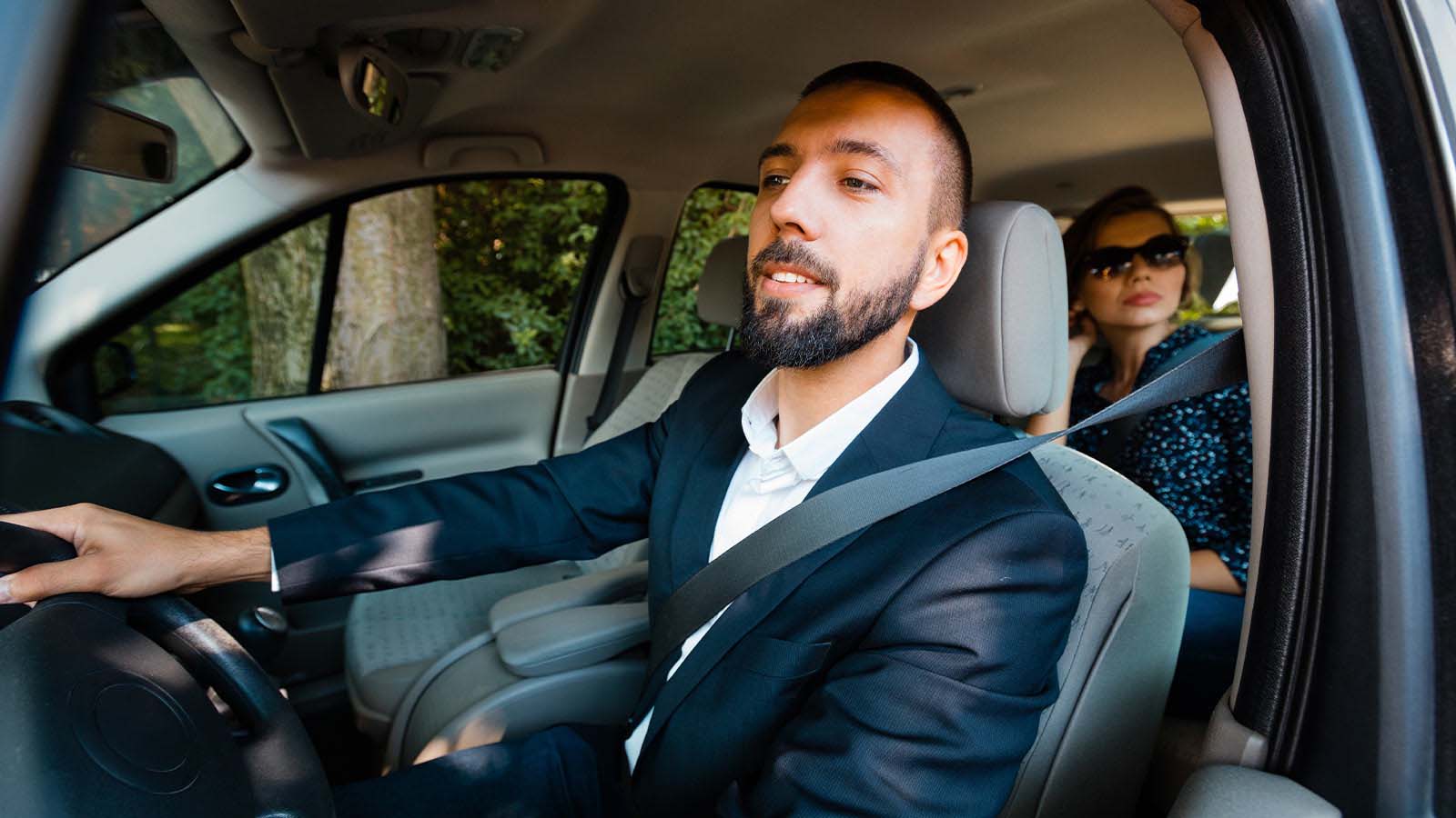 Taksikuski kuljettamassa asiakasta, tietäen että vakuutusasiat ovat kunnossa.