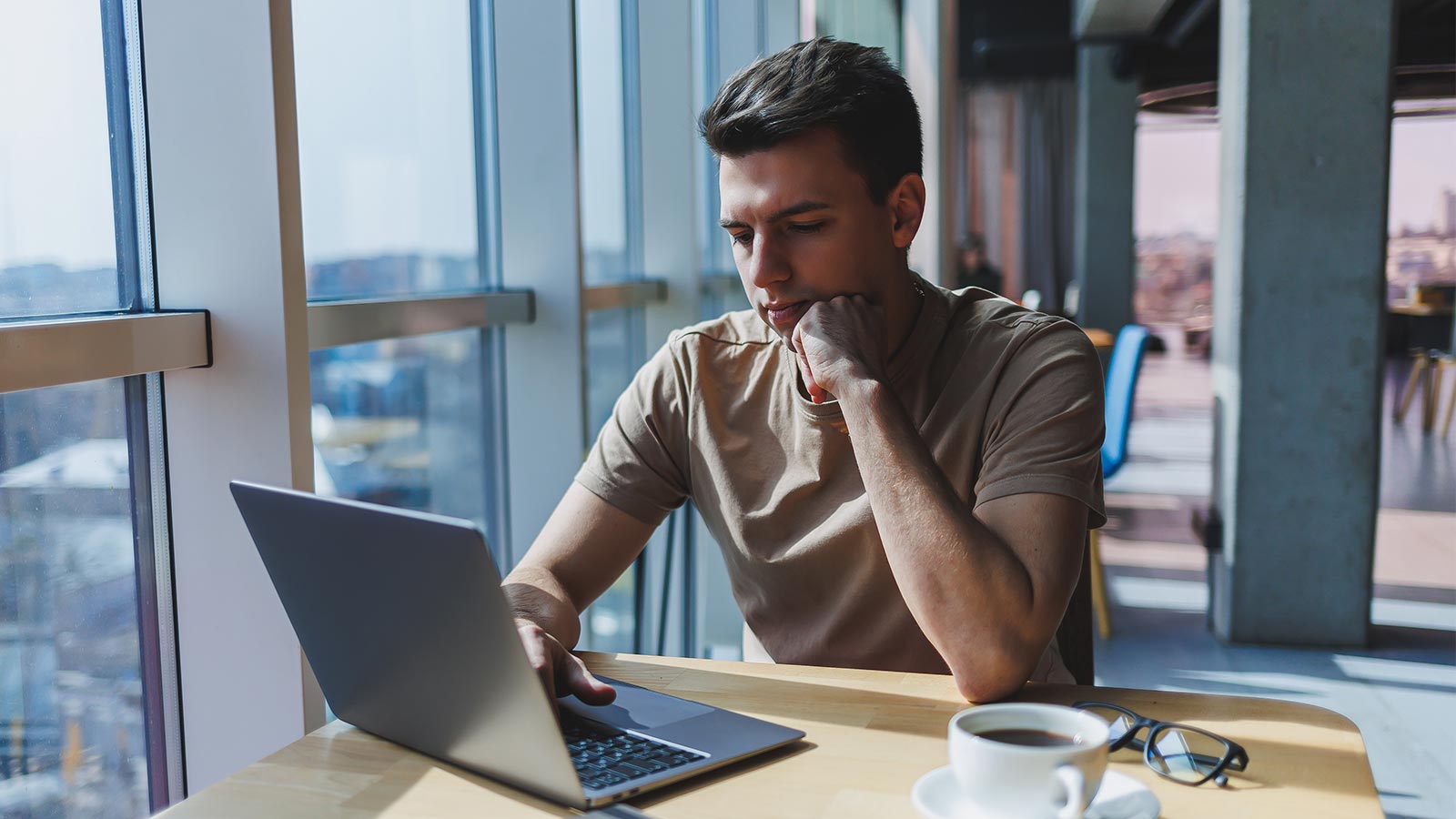 Mies istuu pöydän ääressä ja tutkii tietokoneellaan artikkelia aiheesta valtakirja yrityksen vakuutusasiointiin.