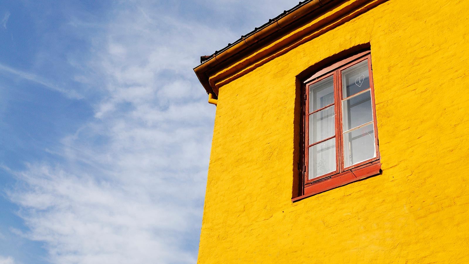 Kerrostalon ylin kerros taivasta vasten.