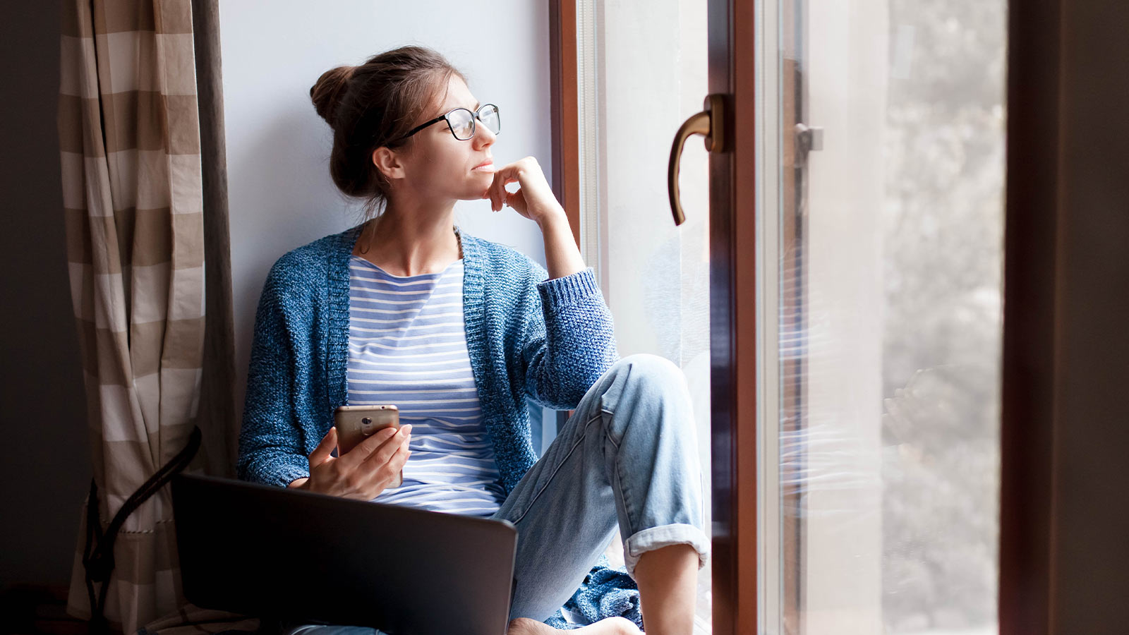 Nainen tutkii omaisuuden ja toiminnan kyberriskejä tietokoneellaan.