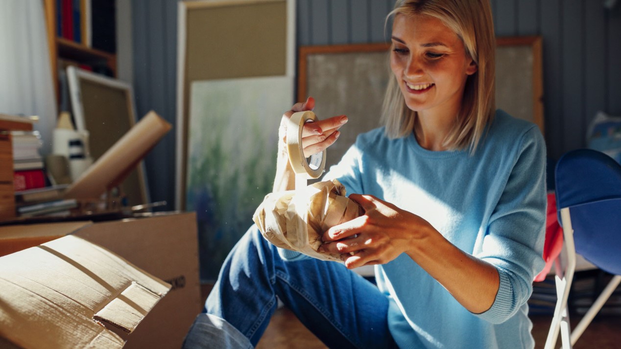 Nainen teippaa särkyvää pakettia