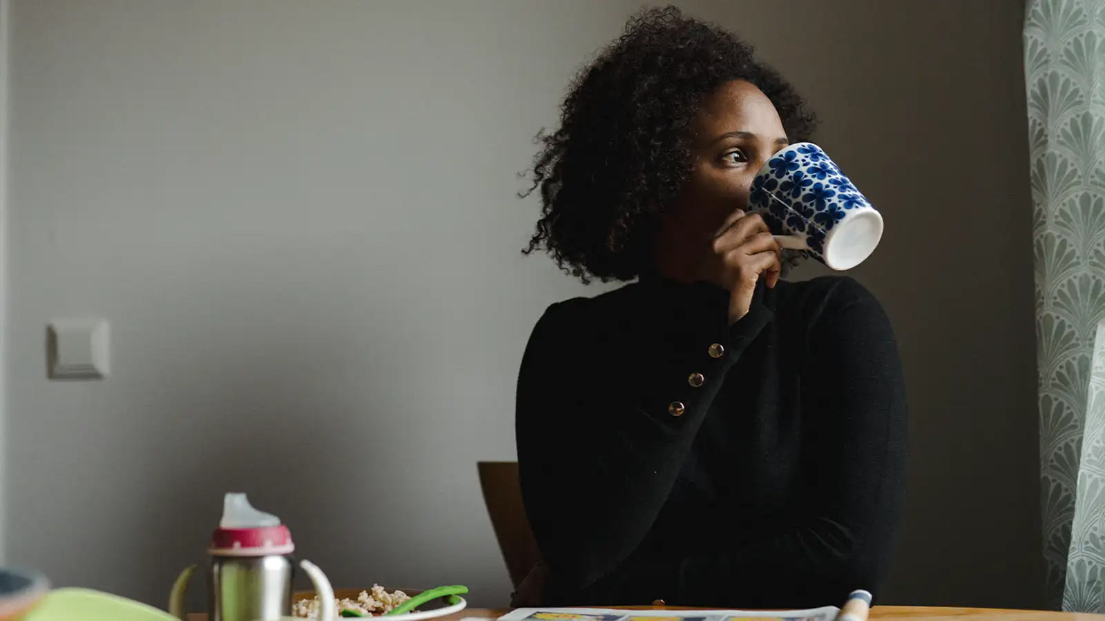 Nainen juo kahvia huolettomasti, sillä hänellä on Terveysturva.