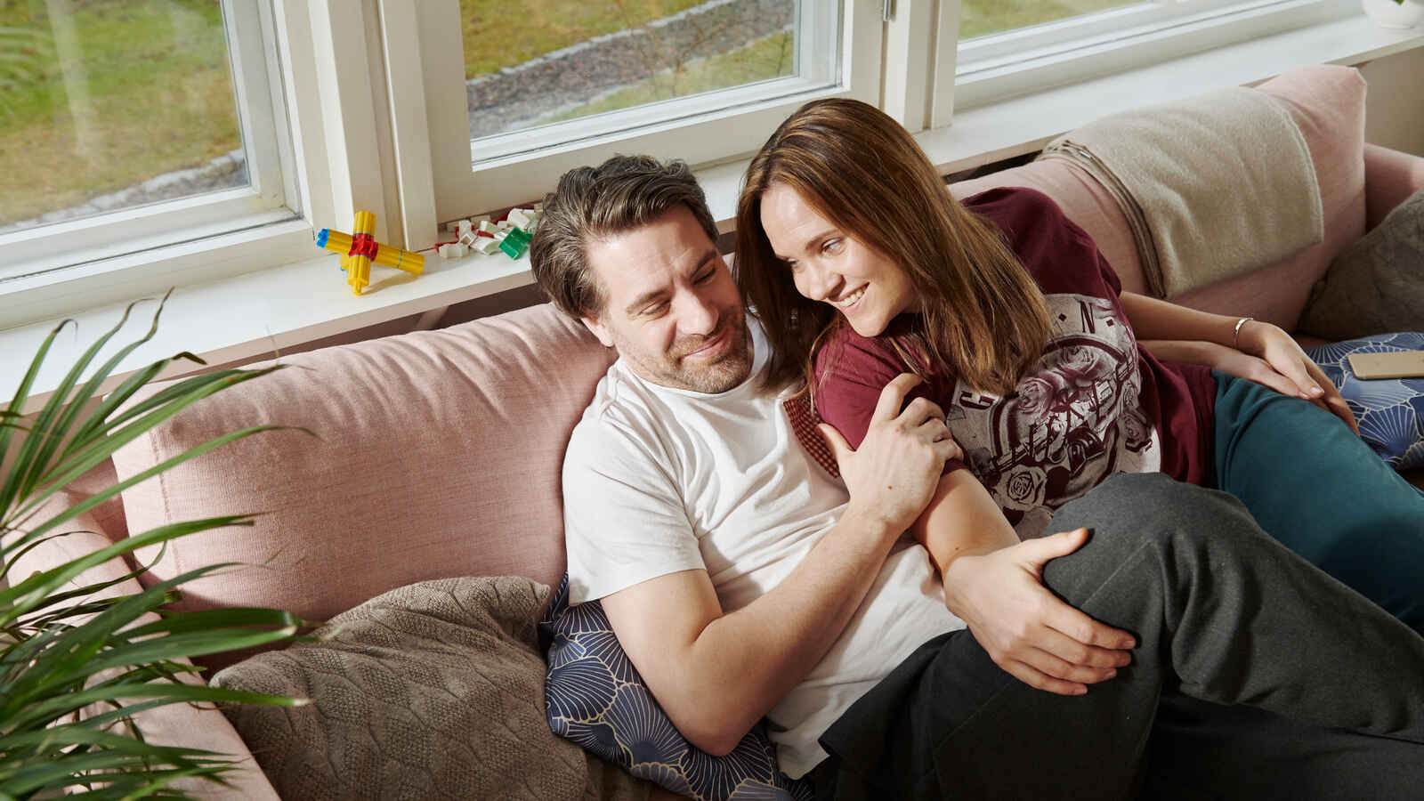 Pariskunta halailee kotisohvalla