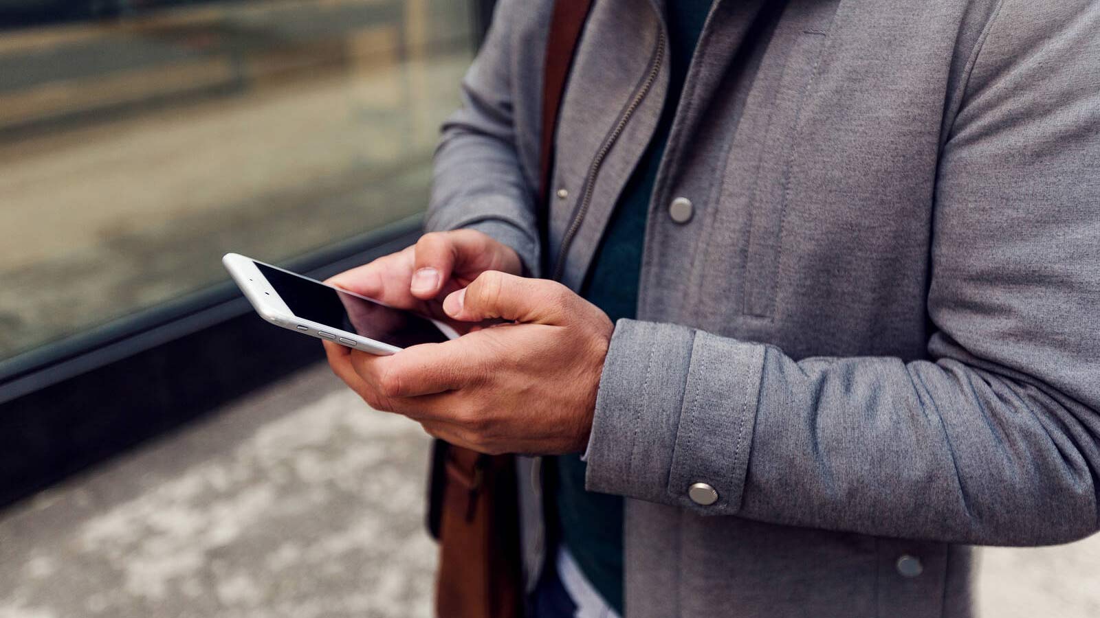 Kuvassa henkilö puhelin kädessä