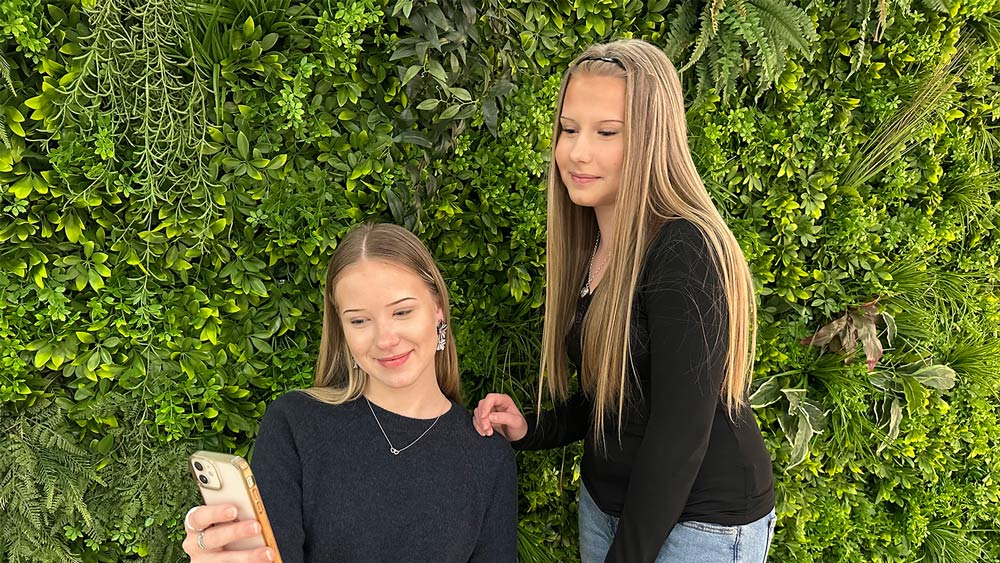 Nuoret tutkimassa yhdessä kännykkää.