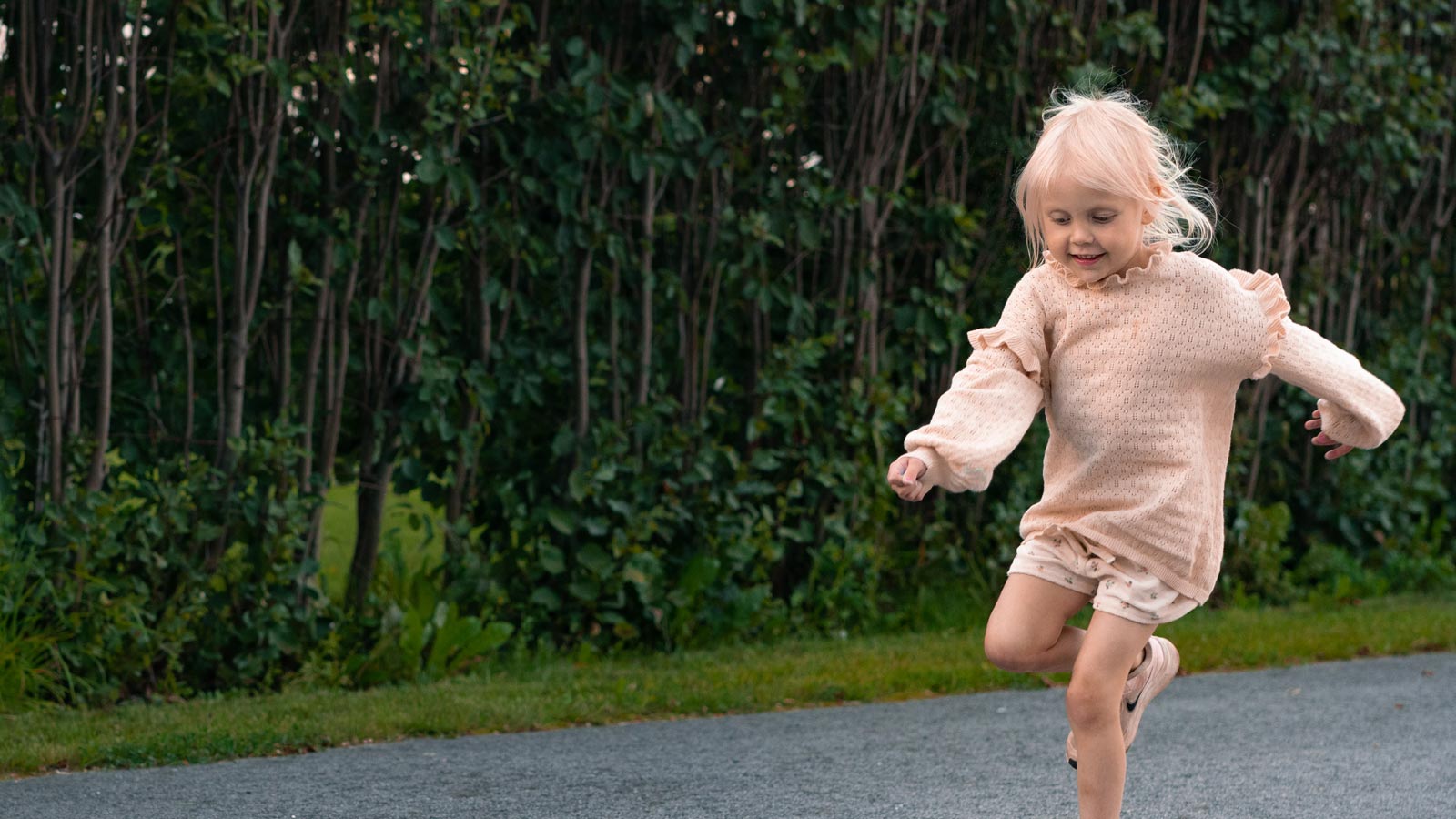 Pieni tyttö hyppelee ruutuhyppelyä.